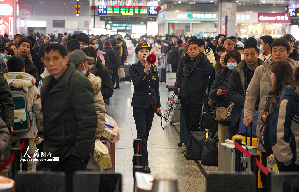 1月21日，鐵路寧波站，客運員在組織旅客有序進站。