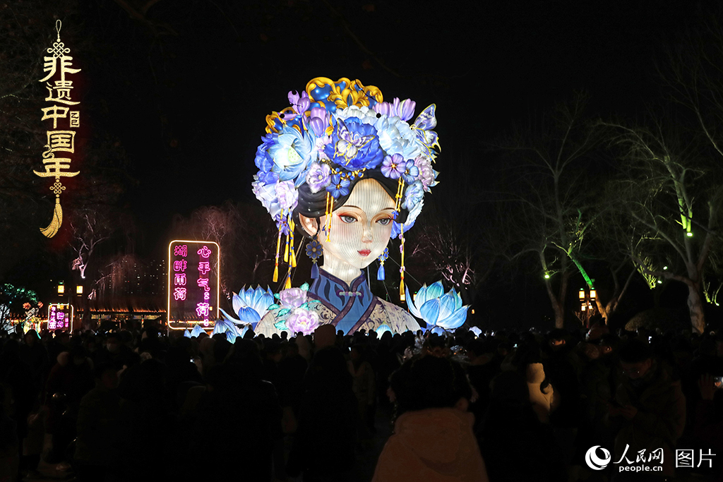 2025年2月9日晚，山东济南大明湖景区内以“夏雨荷”为主题的灯展现场，游客在“湖畔雨荷”花灯前打卡拍照。人民网记者 刘祺摄