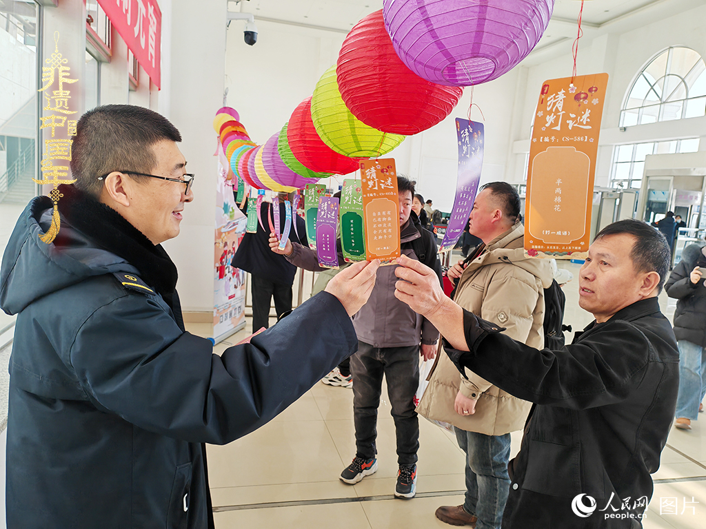 2025年2月11日，宁夏银川车务段灵武火车站的工作人员与旅客进行猜灯谜趣味互动。人民网记者 梁宏鑫摄