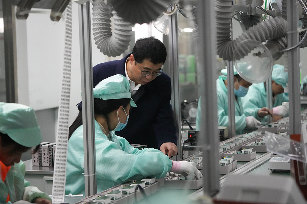 在温州市龙湾区一家专精特新企业，胡东方在生产线与工人交流（2025年2月18日摄）。