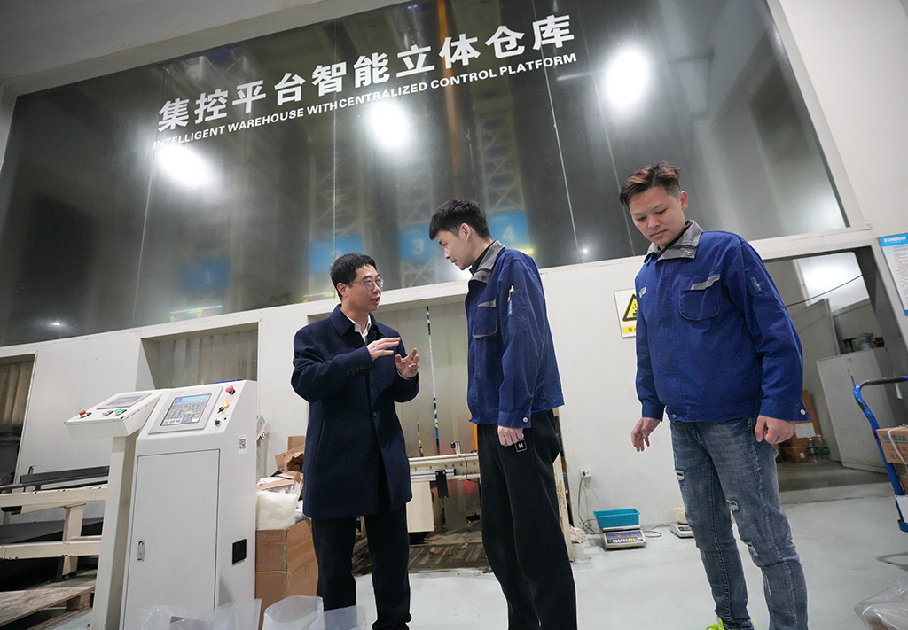 在浙江省温州市一家专精特新企业，胡东方（左）向一线工人了解智能设备运行情况（2025年2月18日摄）。