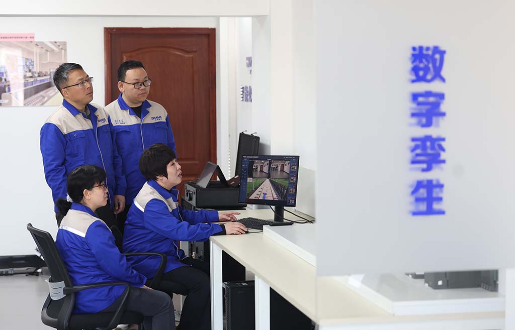 在大连华锐重工集团股份有限公司智能化实验室，孙元华（右下）和同事操作焦炉机械智能决策分析系统（2025年2月20日摄）。