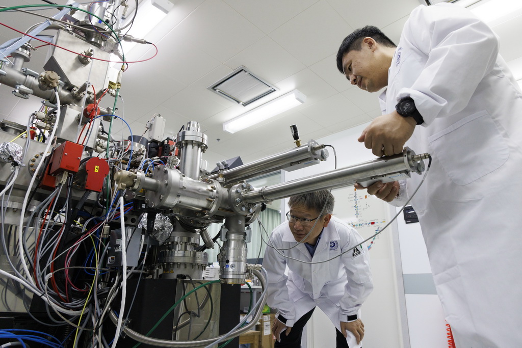 4月8日，在中国科学院地质与地球物理研究所纳米离子探针实验室，胡森研究员（左）、郝佳龙高级工程师放置月球样品。