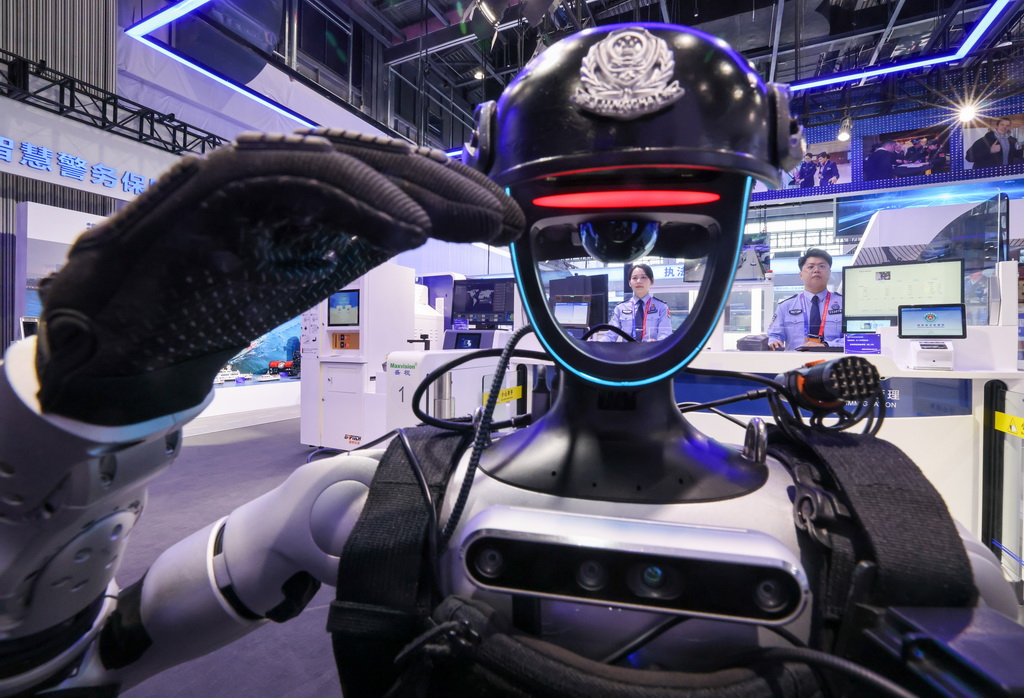 5月14日,在第十二屆中國國際警用裝備博覽會移民管理裝備展區,具身人形智能警務機器人在舉手敬禮。新華社記者 殷剛 攝