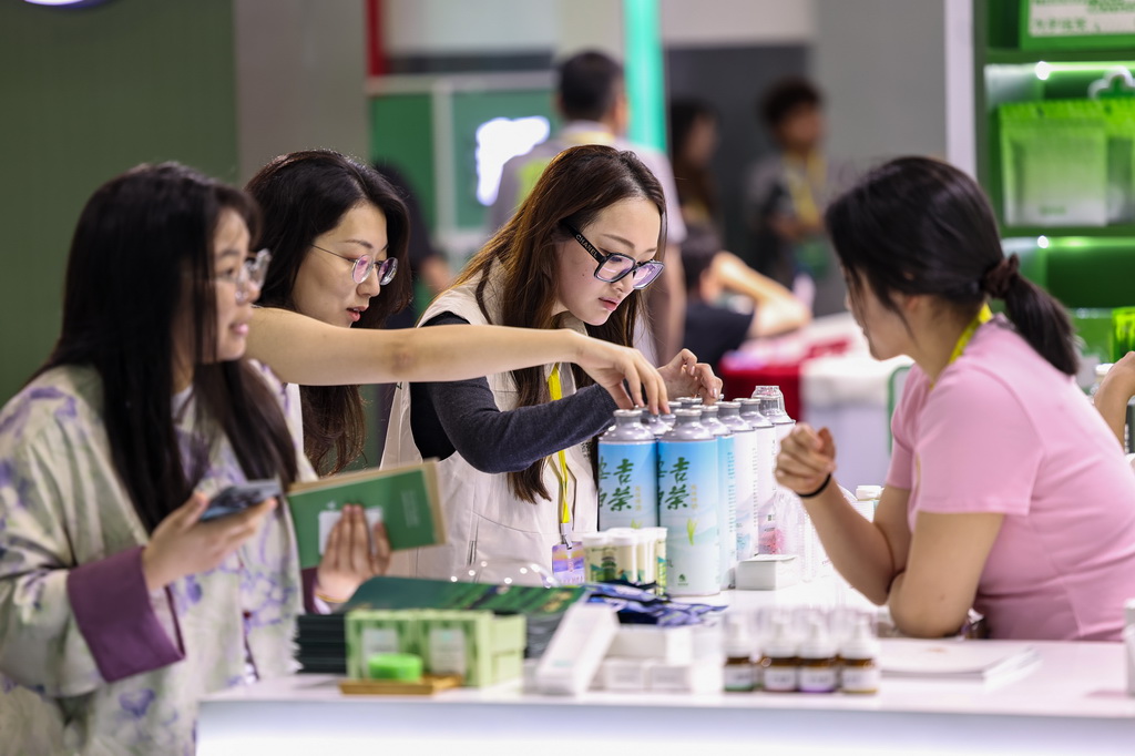 5月21日,觀眾在第七屆中國國際茶葉博覽會現場挑選安吉白茶茶飲。