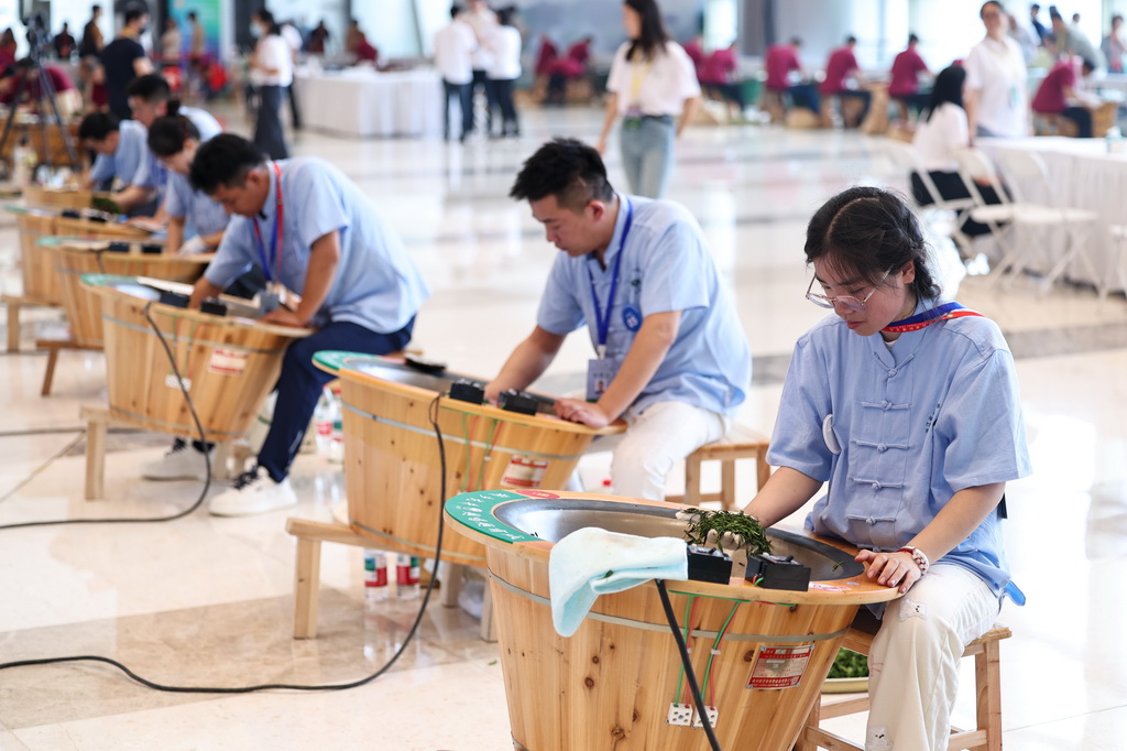 5月21日，参加2025年浙江省龙井茶炒制技能大赛的选手在炒制龙井茶。