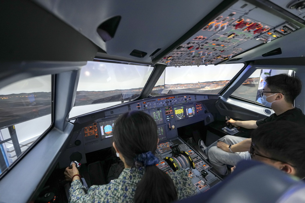 5月26日,在第三届民航科教创新成果展的中国南方航空公司展区,参观者在体验南航自主研制的空客A320飞行与导航程序训练器(FNPT)。