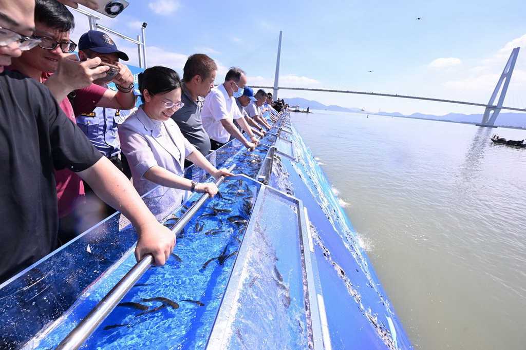 6月6日，在福建省福州市闽江入海口举行的全国水生生物同步增殖放流主会场活动中，嘉宾在投放鱼苗。