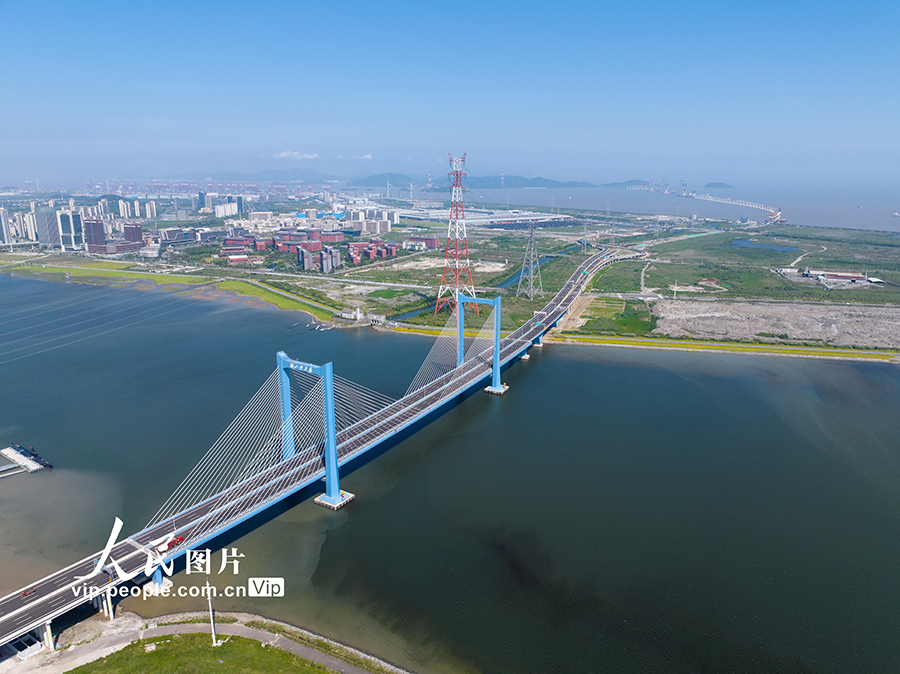 6月6日,宁波舟山港六横公路大桥一期工程通车,远处海上为正在建设中的二期工程。