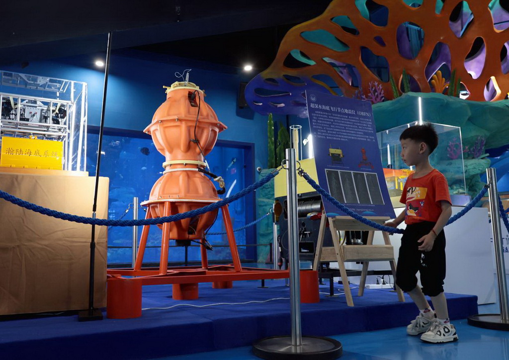 6月7日，一名小朋友在展览现场了解超深水海底飞行节点地震仪。