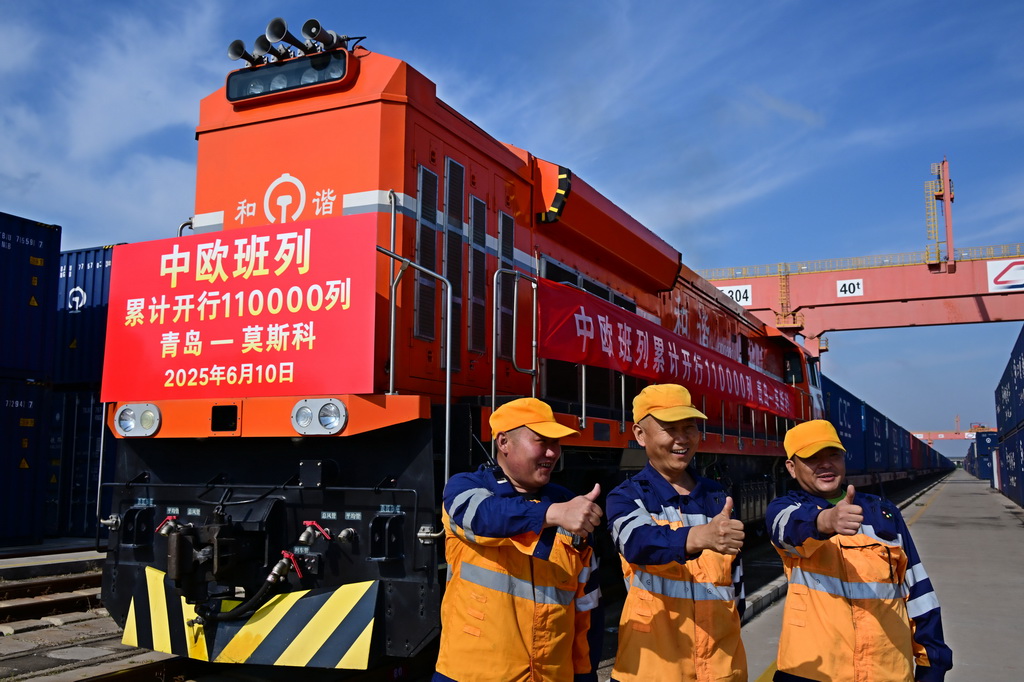 6月10日，在青岛胶州站，铁路工人在75052次中欧班列发车前合影。新华社记者 李紫恒 摄