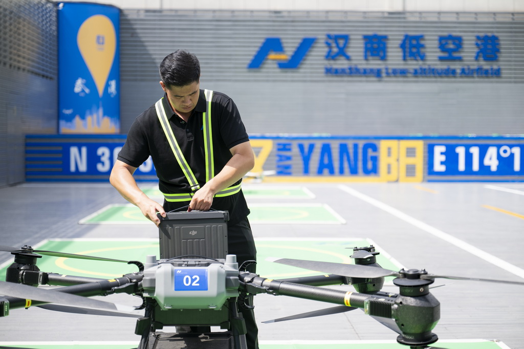 6月16日，在汉商低空港停机坪，一名工作人员给无人机更换电池。