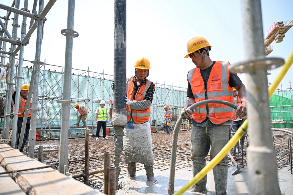 6月18日，中铁建设集团工人在雄忻高铁望都北站建设现场浇筑水泥。