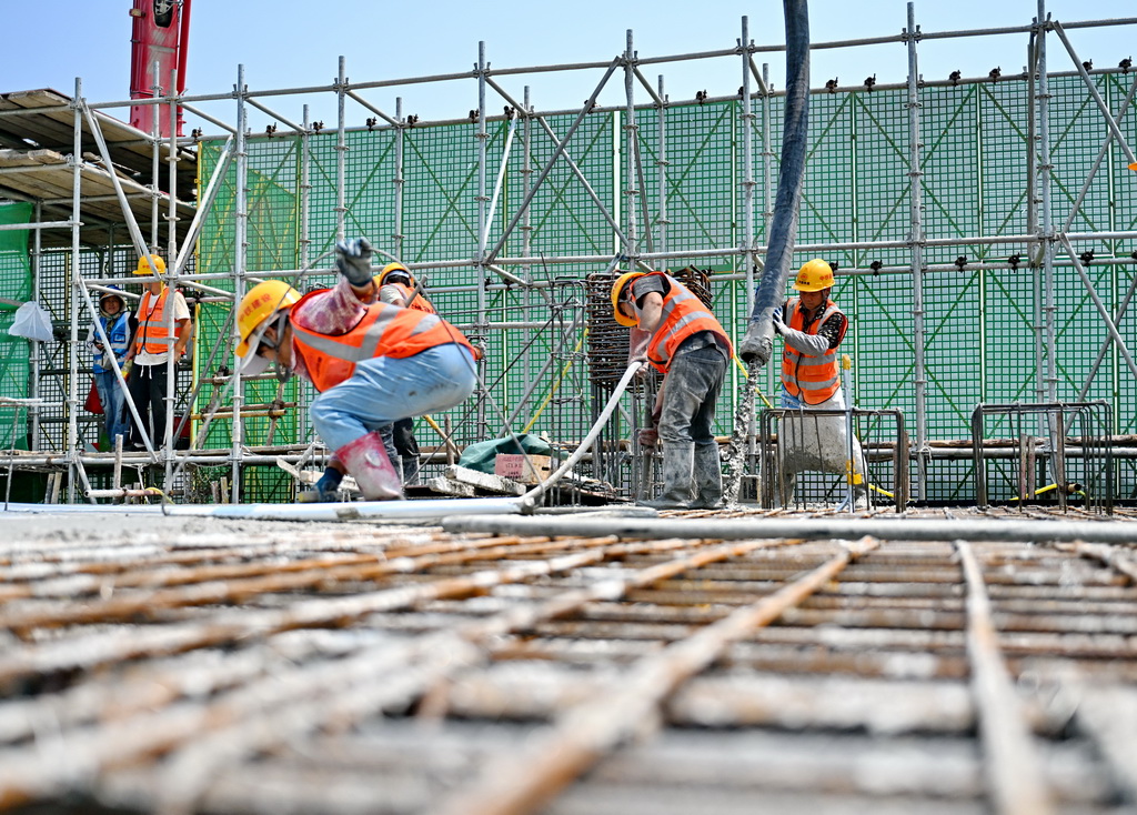 6月18日，中铁建设集团工人在雄忻高铁望都北站建设现场浇筑水泥。