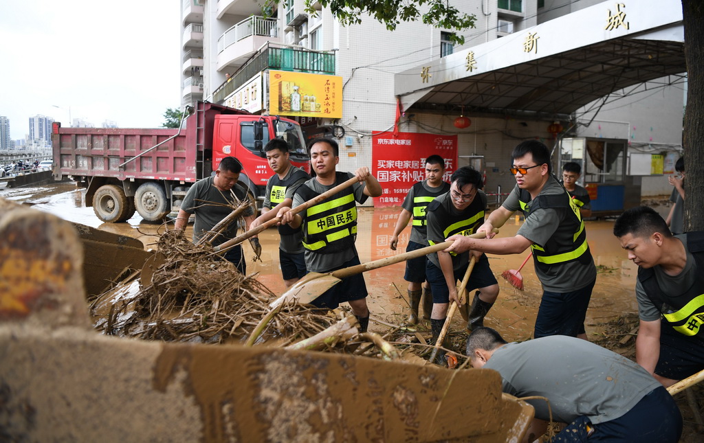 6月19日，民兵在廣東省肇慶市懷集縣城的沿江西路清理雜物、淤泥。