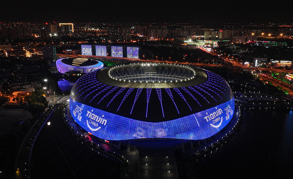 天津奥体中心体育场点亮夏季达沃斯主题灯光（无人机照片，6月20日摄）。