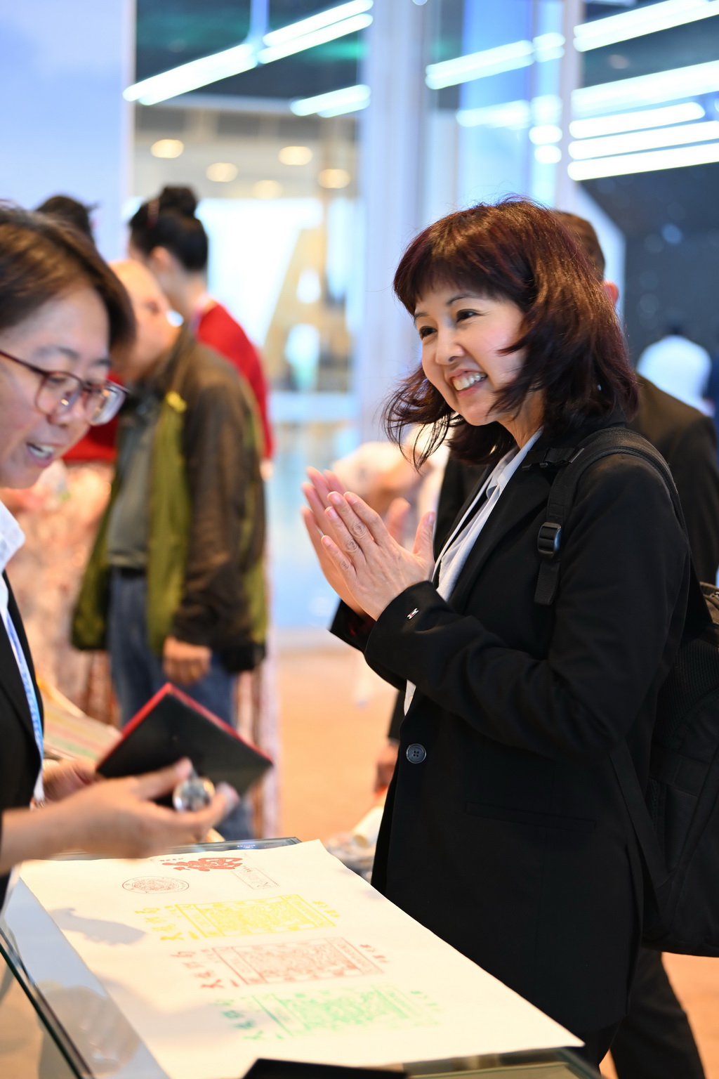 6月25日，嘉賓在第十六屆夏季達沃斯論壇文化之夜中國郵政展台處領取文創產品。新華社記者 李然 攝