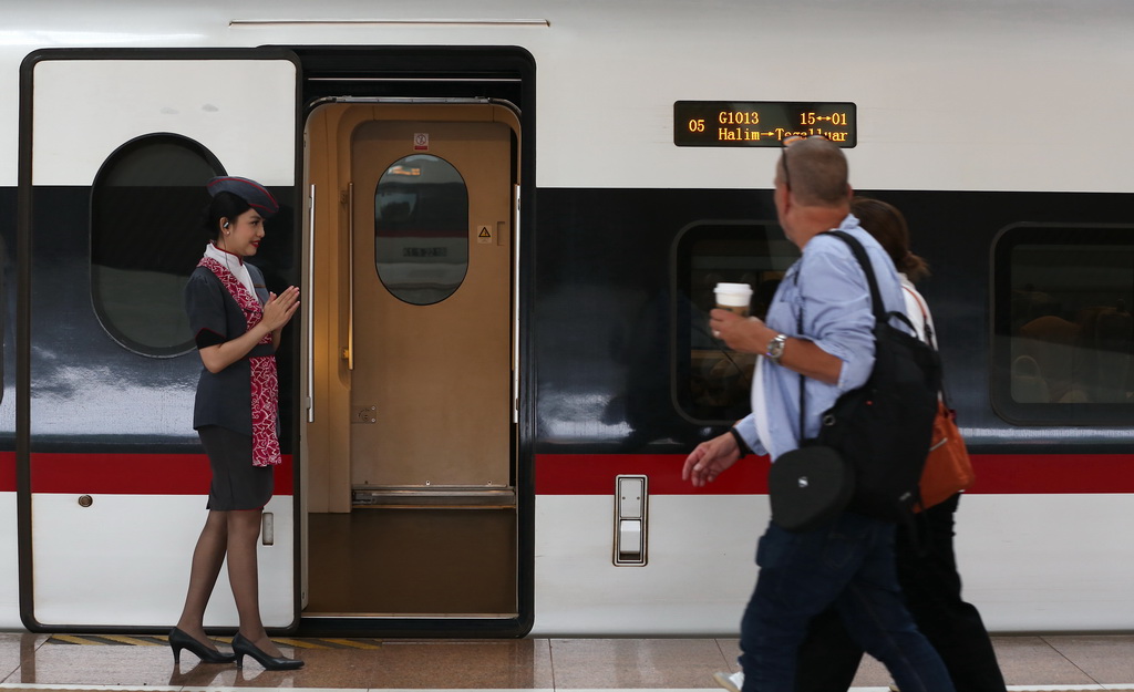 6月19日，一名乘務人員在印度尼西亞雅加達哈利姆站站台歡迎乘客。