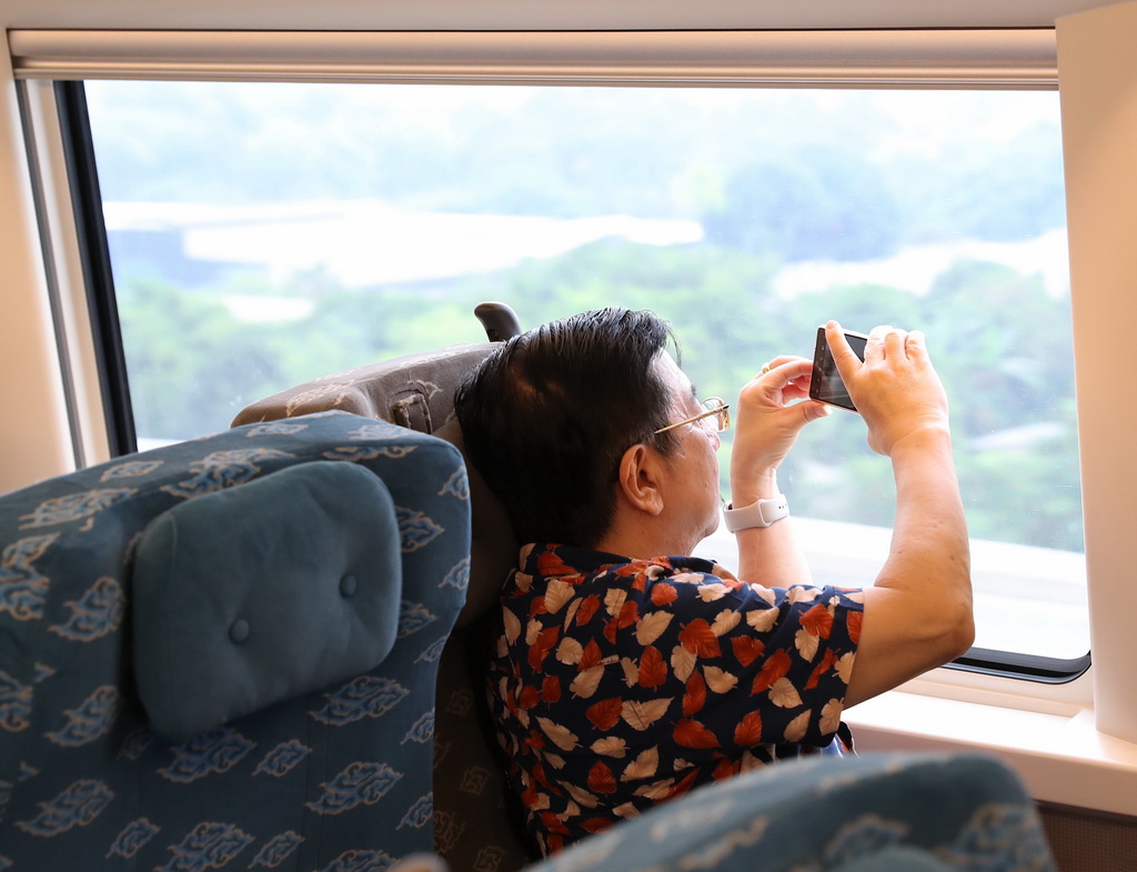 6月19日，一名乘客在行駛中的雅萬高鐵車廂內拍攝沿途風景。