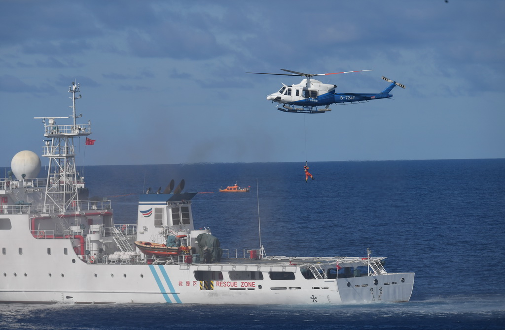 6月26日，救助直升机和船舶在西沙永兴岛附近海域开展协同演练。