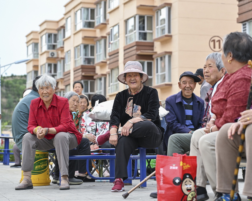 山西省忻州市静乐县小康苑移民安置区居民在小区广场上休息乘凉（7月1日摄）。新华社记者 李鑫 摄