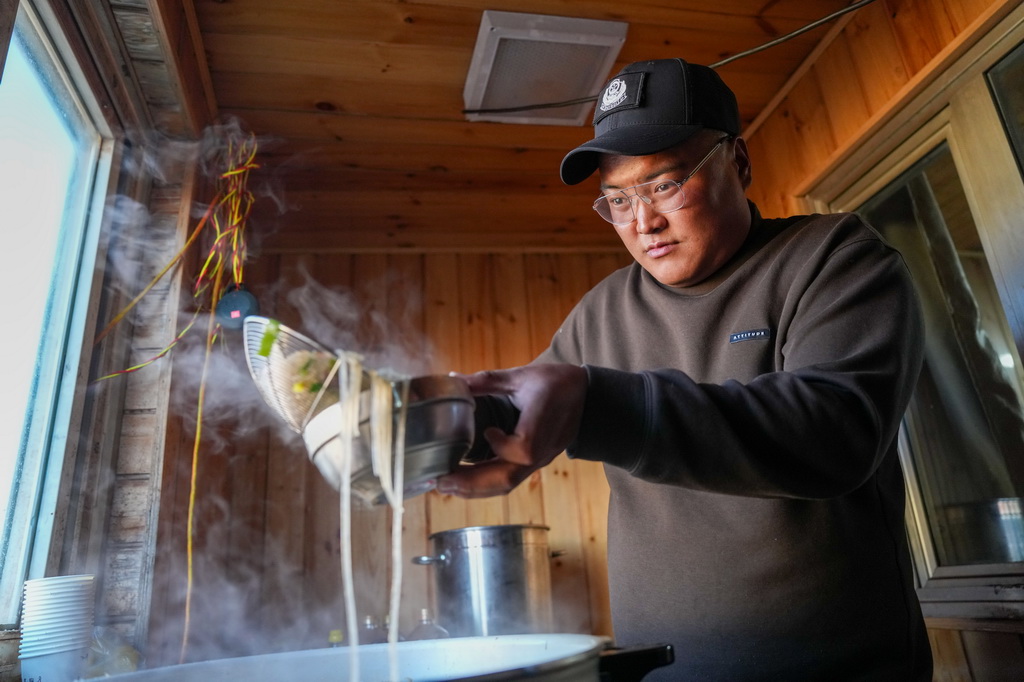 巡山隊員在可可西裡卓乃湖保護站做飯（7月3日攝）。