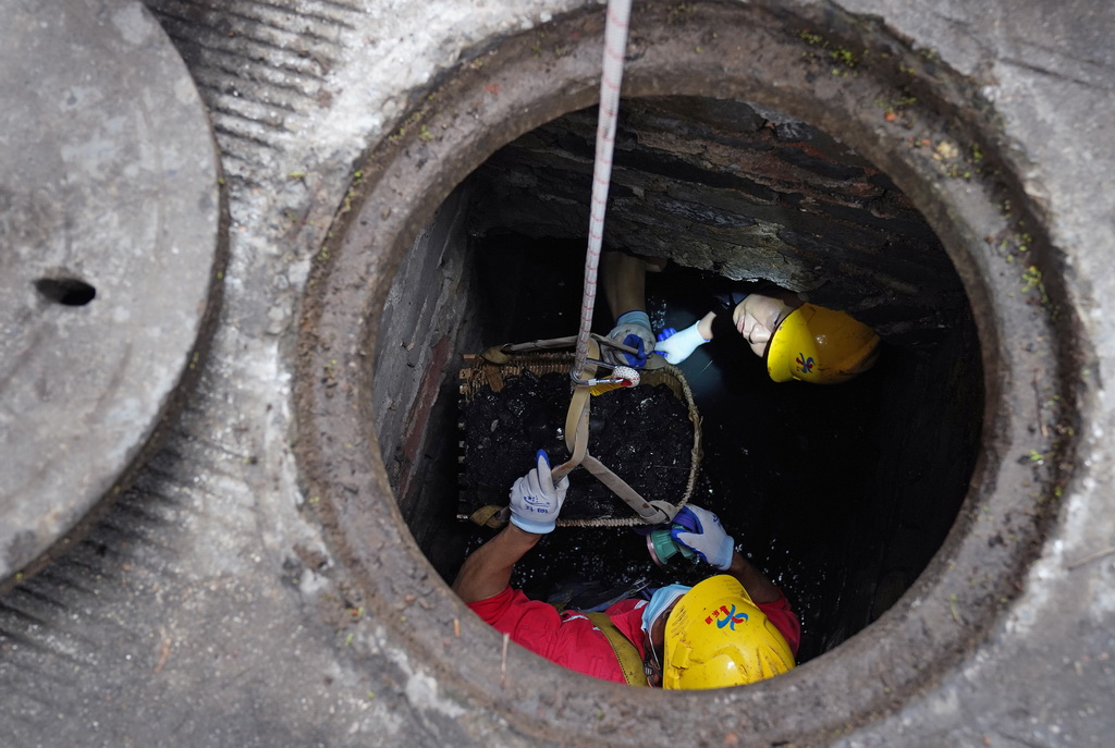 在赣州古城一条街巷,市政工作人员在对福寿沟管网进行清疏(6月18日摄)。