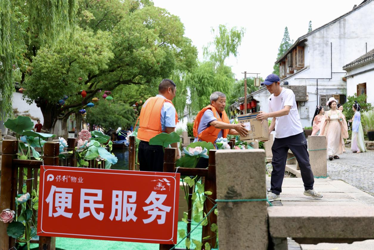 保利物业便民服务船工作人员为商户和原住民搬运货物。蒋雨师摄