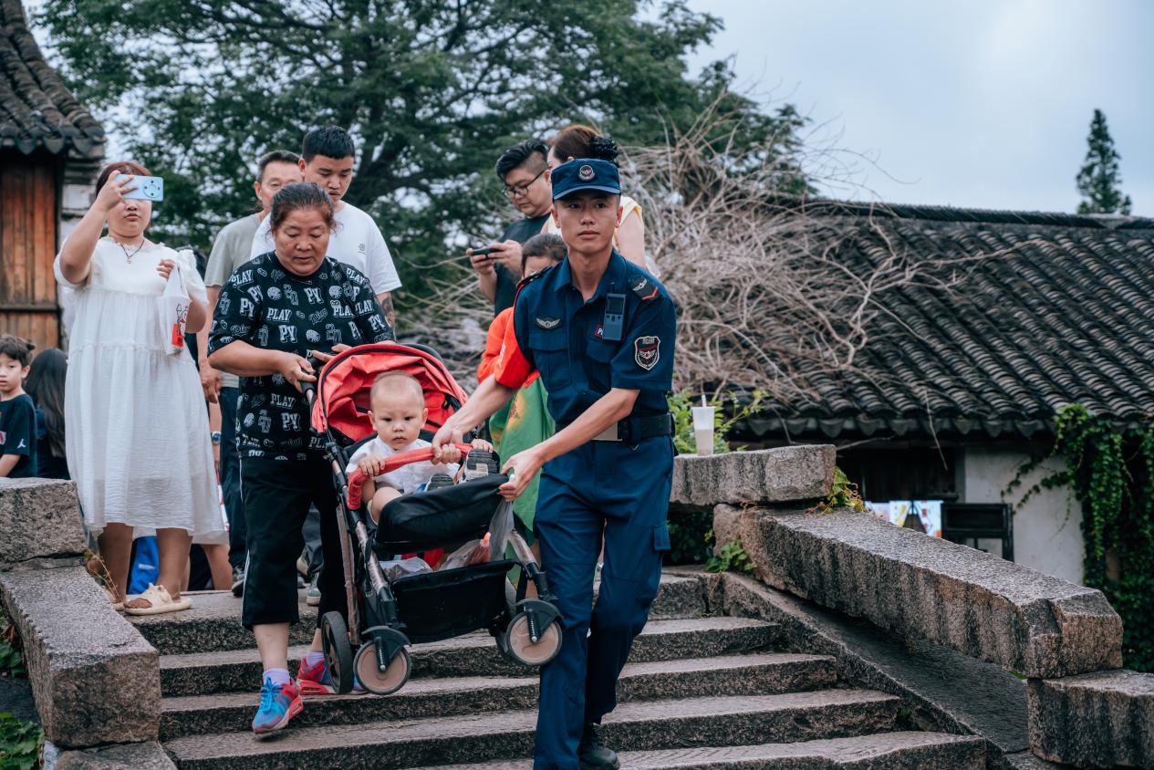 景区桥梁点位上，保利物业工作人员为游客提供帮助。邱活摄