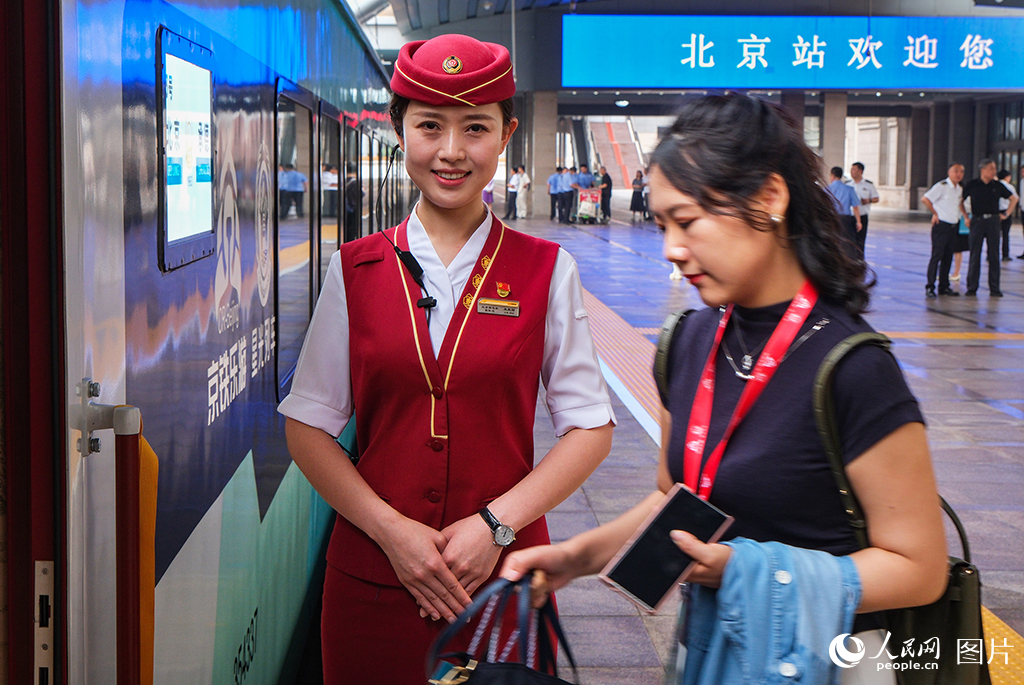 7月9日，乘务员迎接旅客乘车。