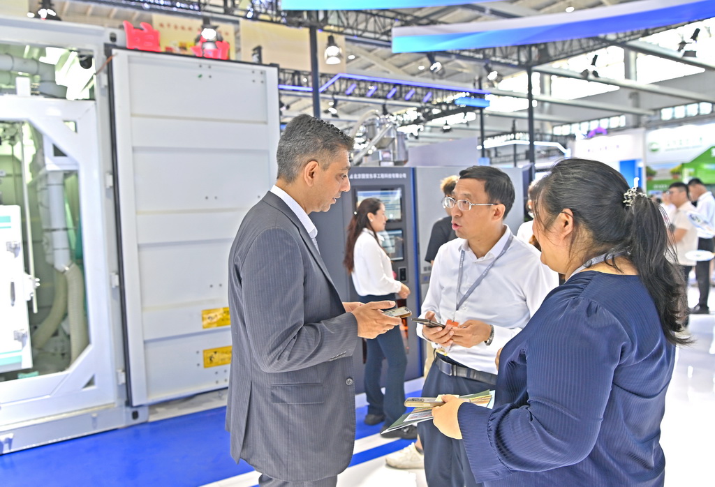 7月12日,国外客商在沈阳国际展览中心了解粮食加工机械。