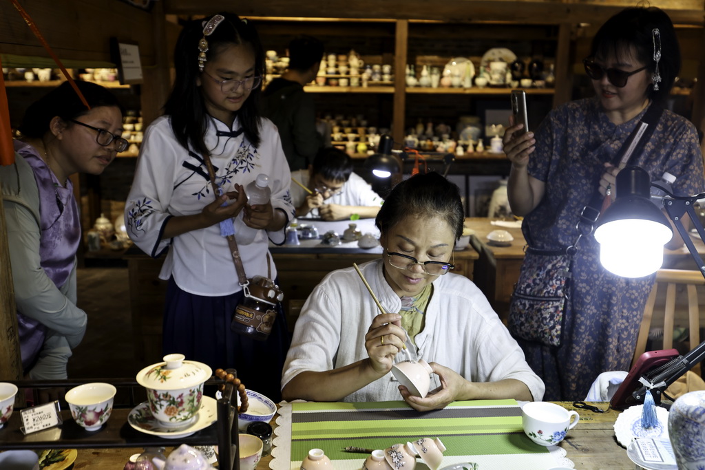 7月13日，游客在江西省景德镇市陶阳里历史文化街区观摩现场创作。