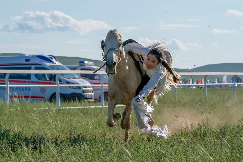 7月20日,选手在骑马拾哈达比赛中。