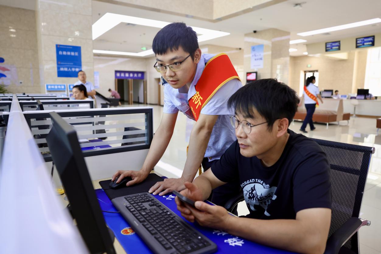 蘭州新區政務服務大廳導稅員在服務市民進行線上稅務辦理。蔣雨師攝