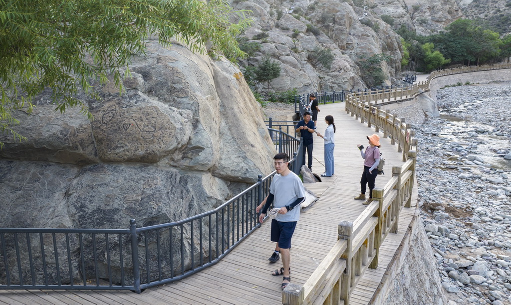 7月23日,游客在賀蘭山岩畫景區游覽(無人機照片)。