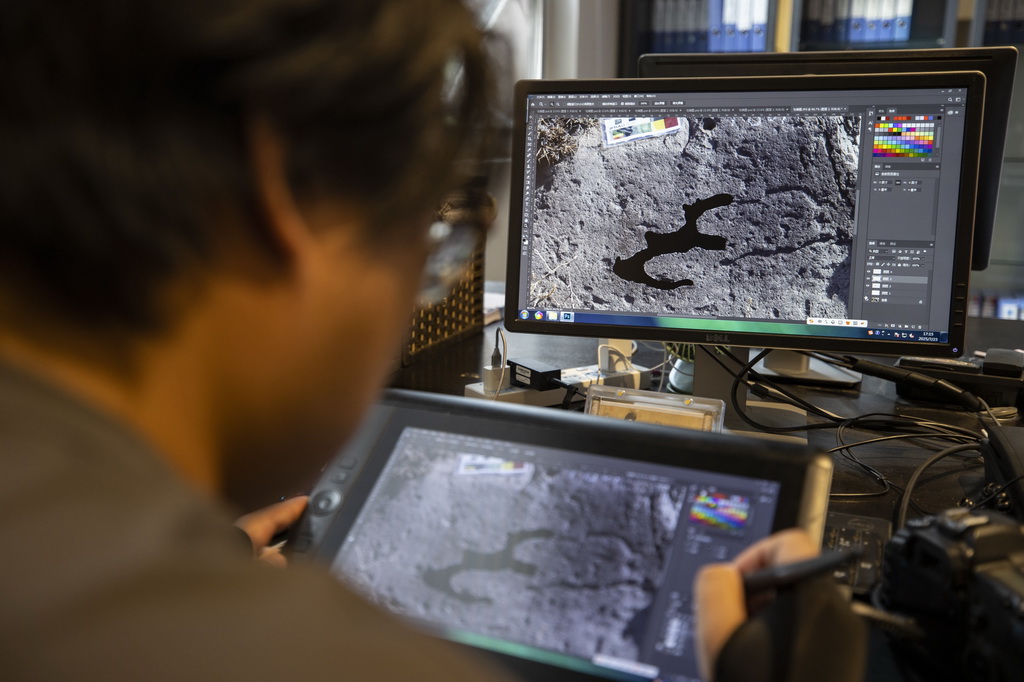 7月23日，工作人員在繪制岩畫電子線描圖。在岩畫普查工作中，岩畫電子線描圖是實景岩畫圖像數字化的一種輔助方式，使畫面清晰明確地呈現在岩畫信息資料庫中，便於日后查閱與研究工作。