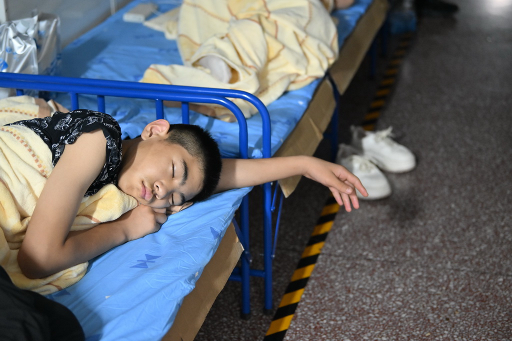 7月29日,一名小朋友在天津市薊州區下營鎮初級中學睡覺。