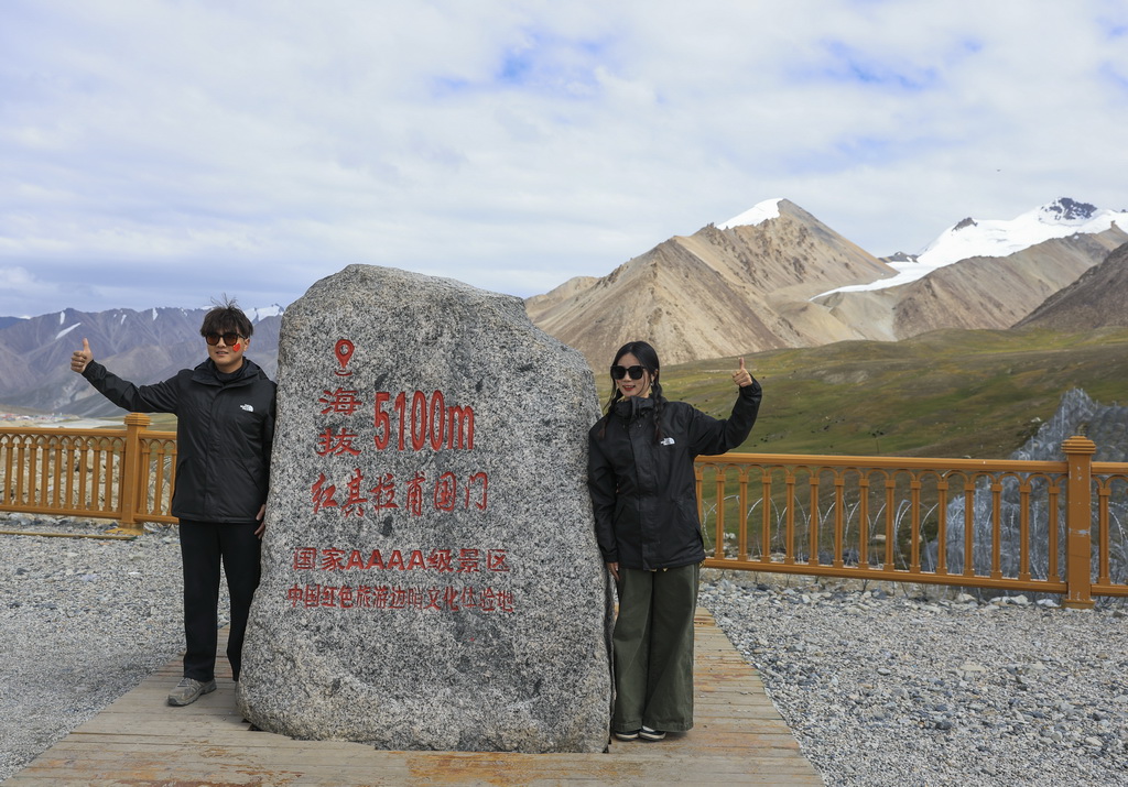 8月2日，游客在位於新疆塔什庫爾干塔吉克自治縣的中巴邊境紅其拉甫口岸拍照留念。