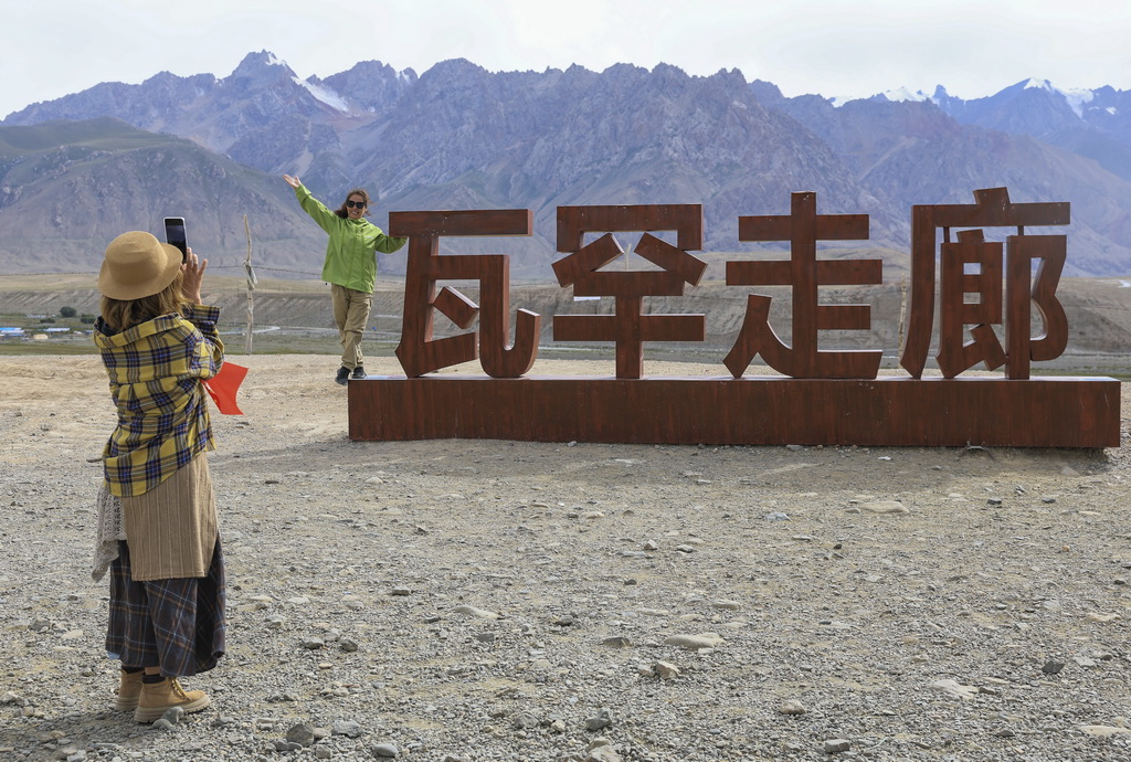 8月2日，游客在位於新疆塔什庫爾干塔吉克自治縣的瓦罕走廊入口處拍照留念。