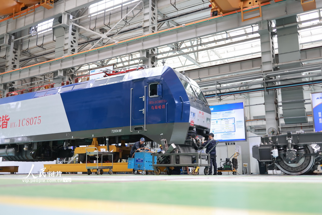 8月7日，成都机务段大功率机车检修车间员工对机车轮对机车底部进行检查作业。