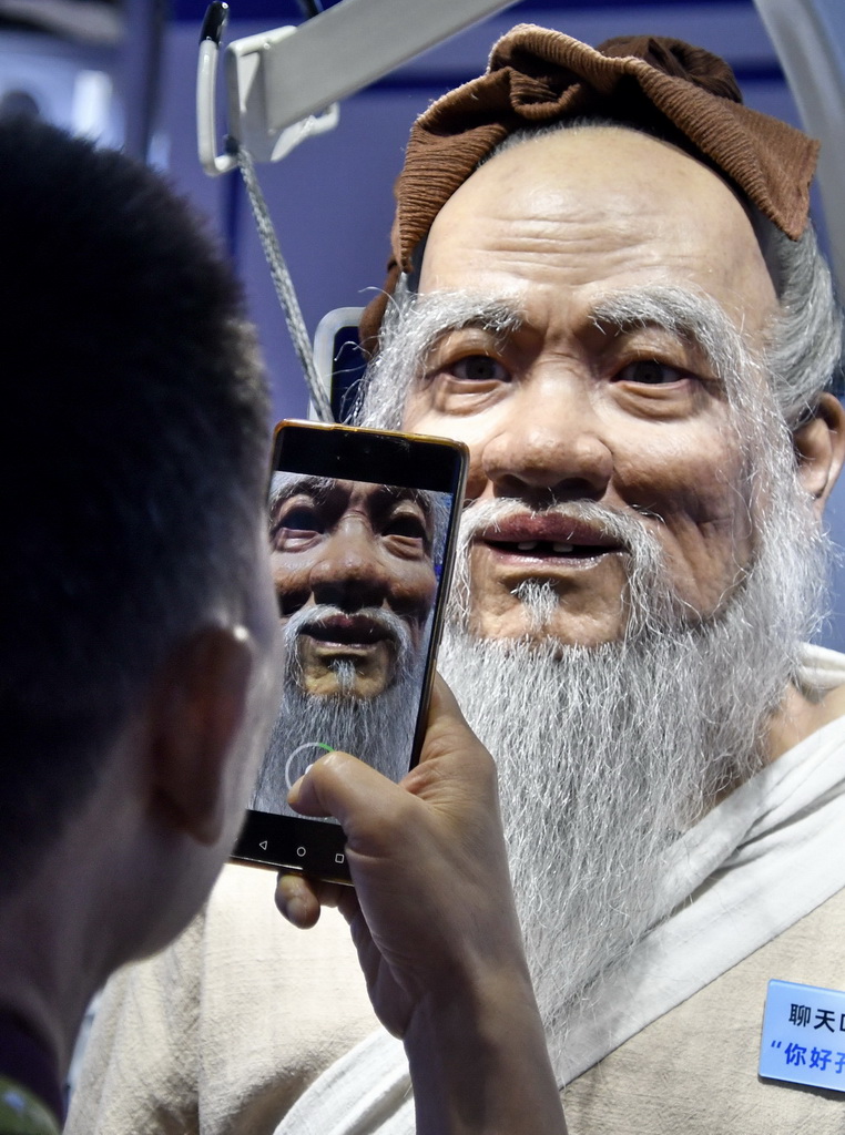 8月8日,觀眾在2025世界機器人大會現場與展出的智能機器人互動。新華社記者 李欣 攝