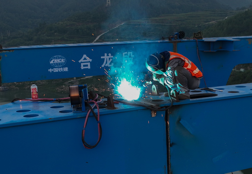 8月18日，工人在进行钢桁梁合龙焊接施工（无人机照片）。