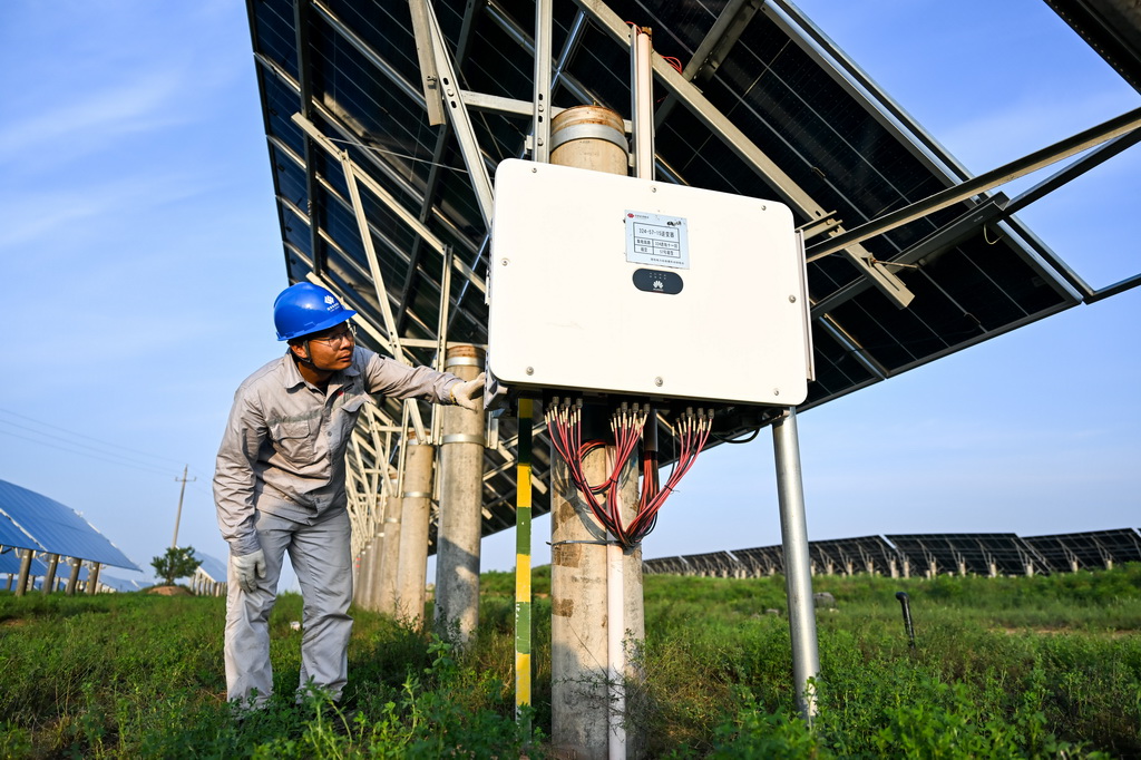 工人在天驕綠能50萬千瓦採煤沉陷區生態治理光伏發電示范項目區巡查光伏發電設備（7月30日攝）。