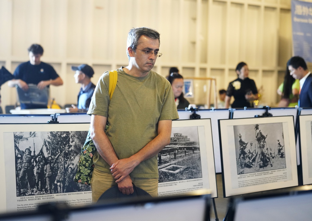 8月30日，在美国旧金山湾区举行的中国人民抗日战争暨世界反法西斯战争胜利80周年纪念活动上，一名参观者观看抗战主题摄影展。