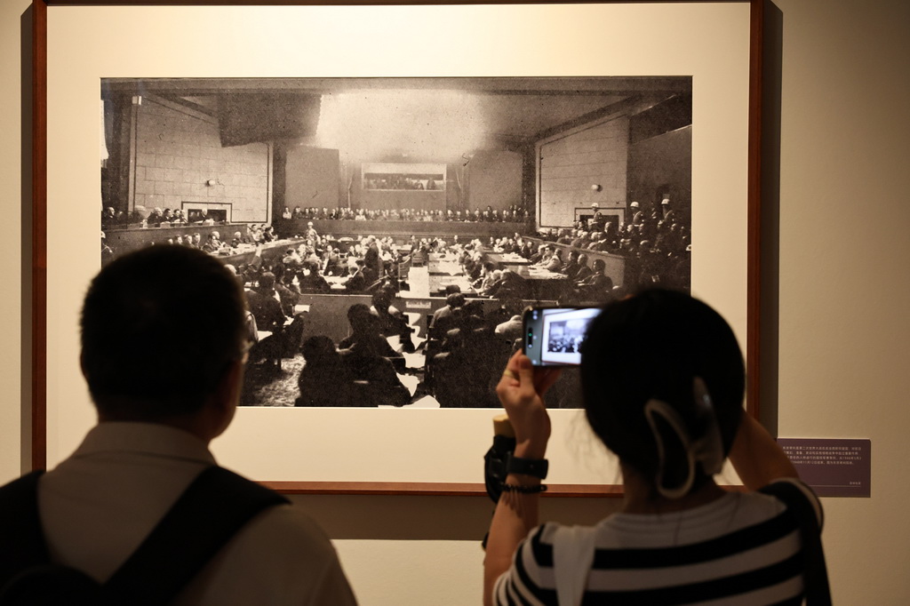 9月1日，參觀者在藝術展上展出的抗戰主題攝影作品前駐足觀看。