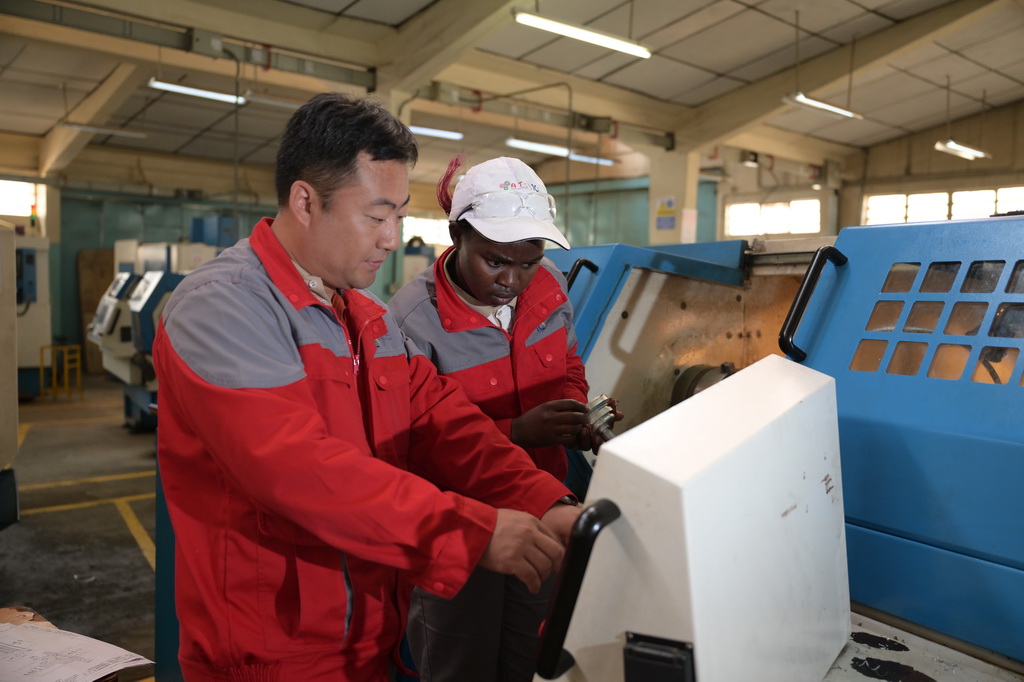 8月29日，在位於肯尼亞首都內羅畢的肯尼亞科技大學，中方指導老師與第十屆非洲職業技能挑戰賽的參賽選手在數控車床前交流。新華社記者 楊光 攝