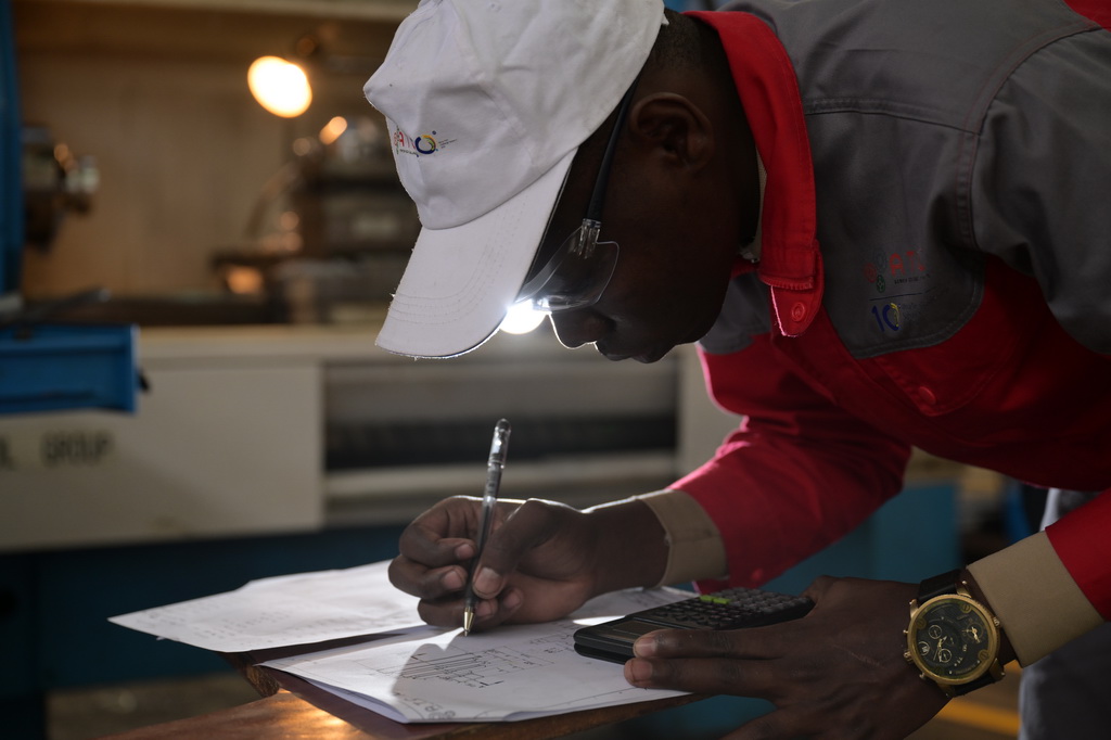 8月29日，在位於肯尼亞首都內羅畢的肯尼亞科技大學，一名第十屆非洲職業技能挑戰賽的參賽選手在數控機床前進行計算。新華社記者 楊光 攝