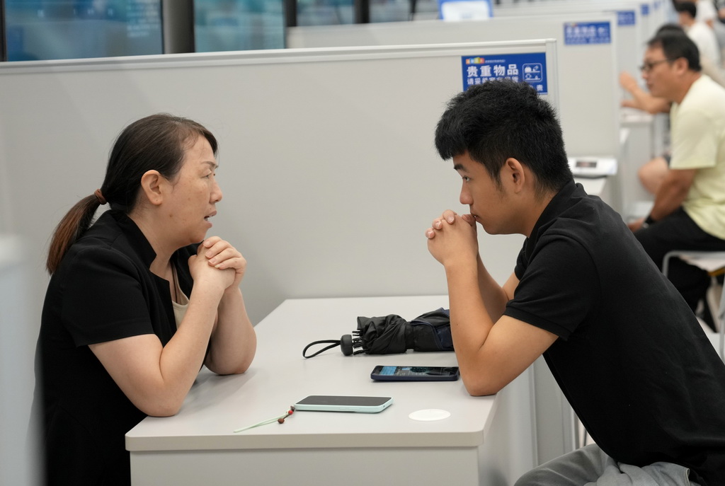9月4日，一名求職者（右）與招聘企業代表在杭州市綜合性人才招聘會上洽談。
