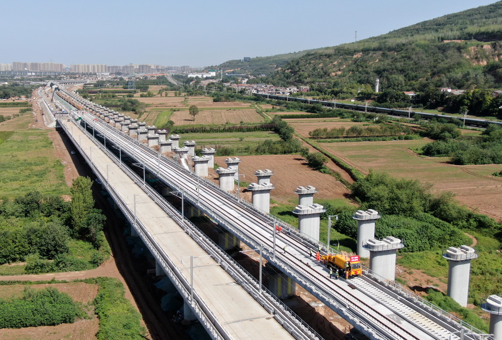 9月8日，施工车辆在西十高铁西安东至蓝田区间铺设无缝钢轨（无人机照片）。