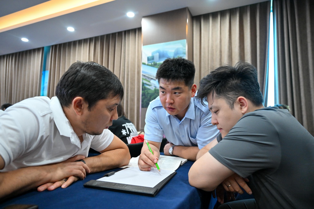 天津軌道交通集團培訓教師張垚(中)在培訓期間通過翻譯為哈薩克斯坦學員答疑(7月14日攝)。